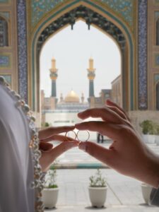 عکس دو حلقه در قاب طاق حرم با گلدسته و گنبد طلایی