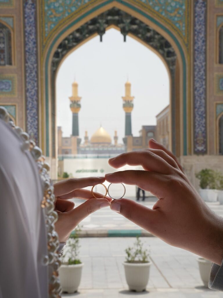 عکس دو حلقه در قاب طاق حرم با گلدسته و گنبد طلایی
