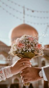 عکس دسته گل رز هلویی در دست زوج مقابل گنبد طلایی