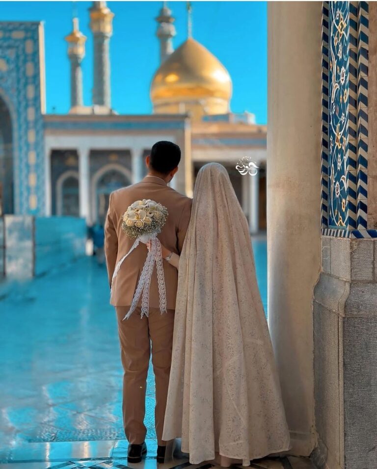 عکس عاشقانه مذهبی زوج مقابل گنبد طلایی و کاشی فیروزه‌ای