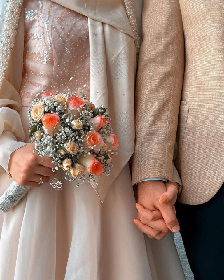 عکس عروس با لباس شامپاینی نگین‌دوزی و دسته گل رز هلویی