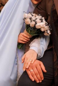 عکس عروس با مانتو آبی روشن و دسته گل لاله سفید