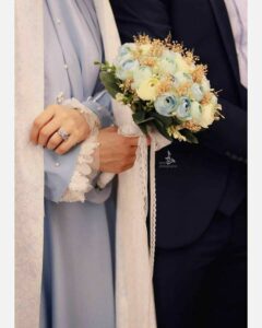 عکس عروس با مانتو آبی پودری و دسته گل آلاله آبی