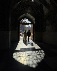 عکس عاشقانه مذهبی زوج در حال خروج از در مسجد در نور