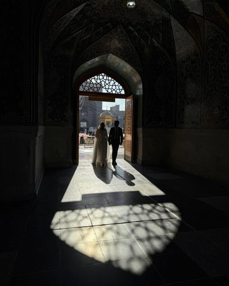 عکس عاشقانه مذهبی زوج در حال خروج از در مسجد در نور