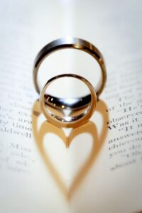 عکس دو حلقه ازدواج روی کتاب با سایه قلبی
