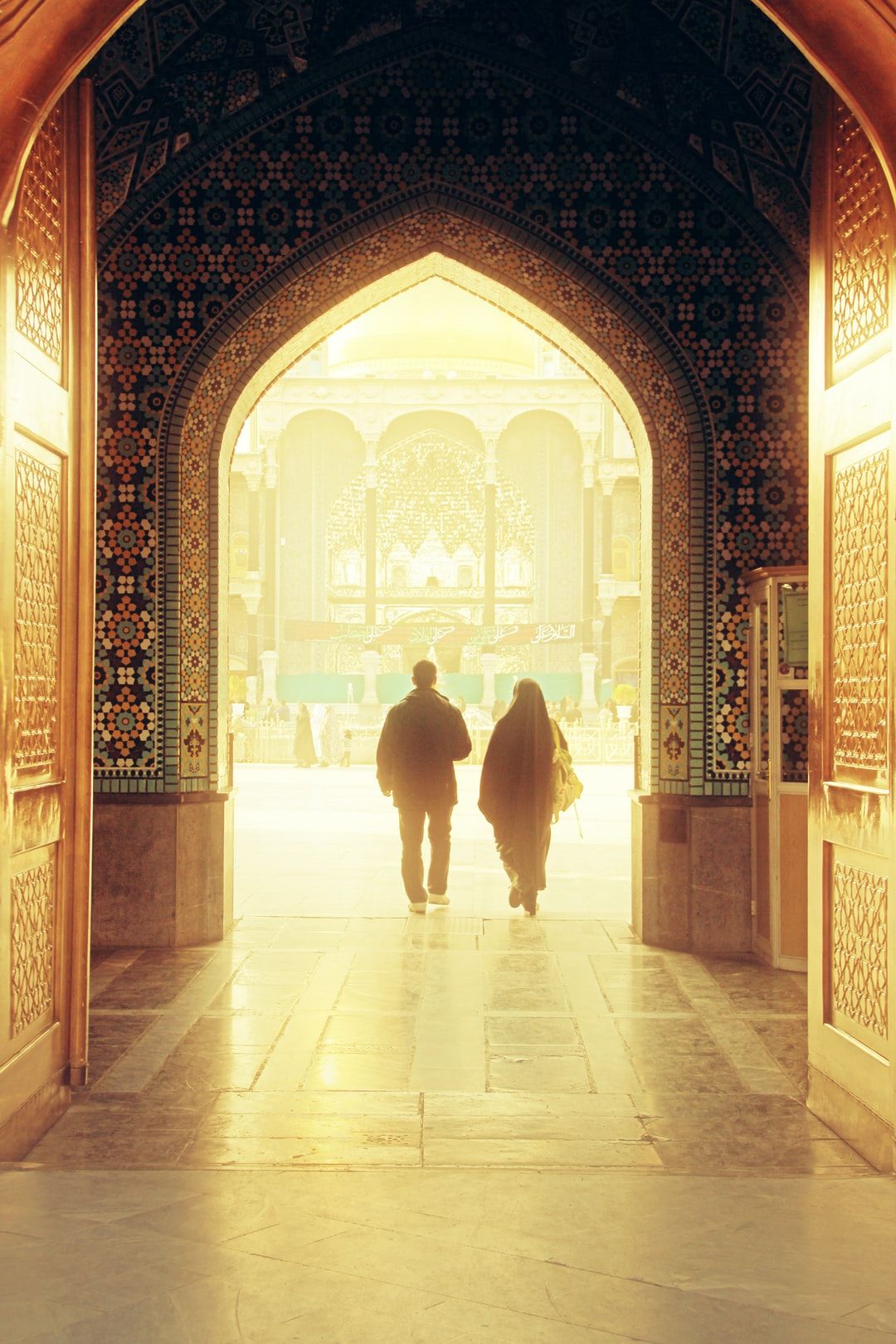 عکس عاشقانه مذهبی زوج در قاب طاق کاشی‌کاری حرم
