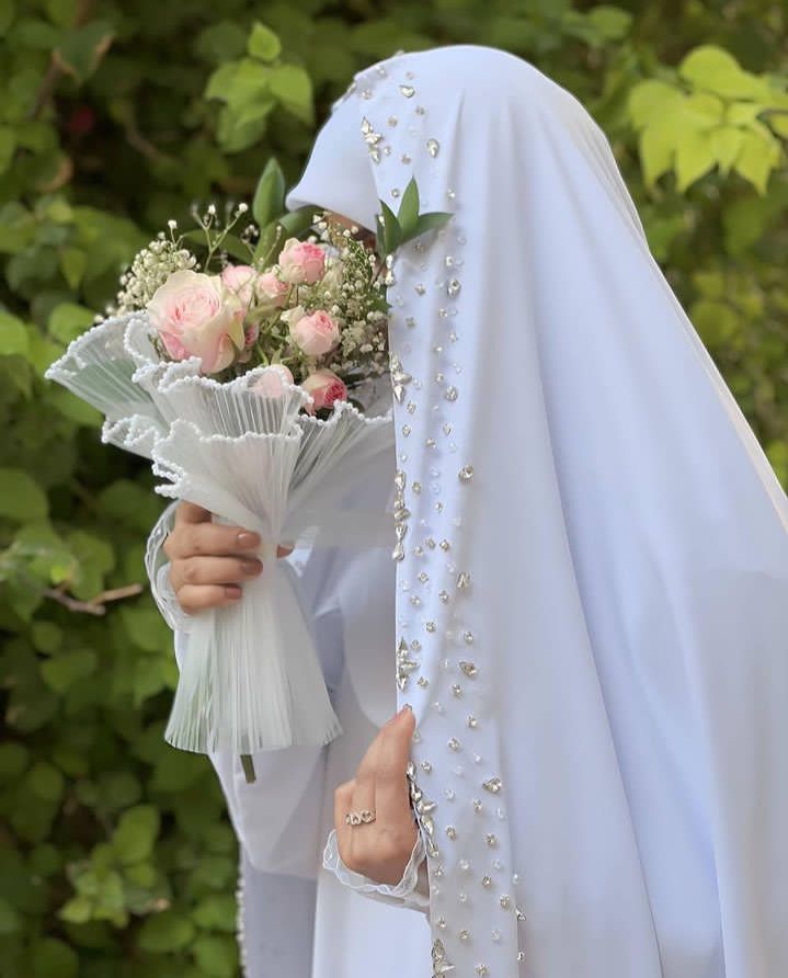 عکس عروس با چادر سفید نگین‌دوزی و دسته گل رز صورتی