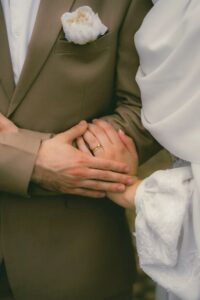 عکس عاشقانه عروس و داماد با کت زیتونی و گل صد تومانی سفید