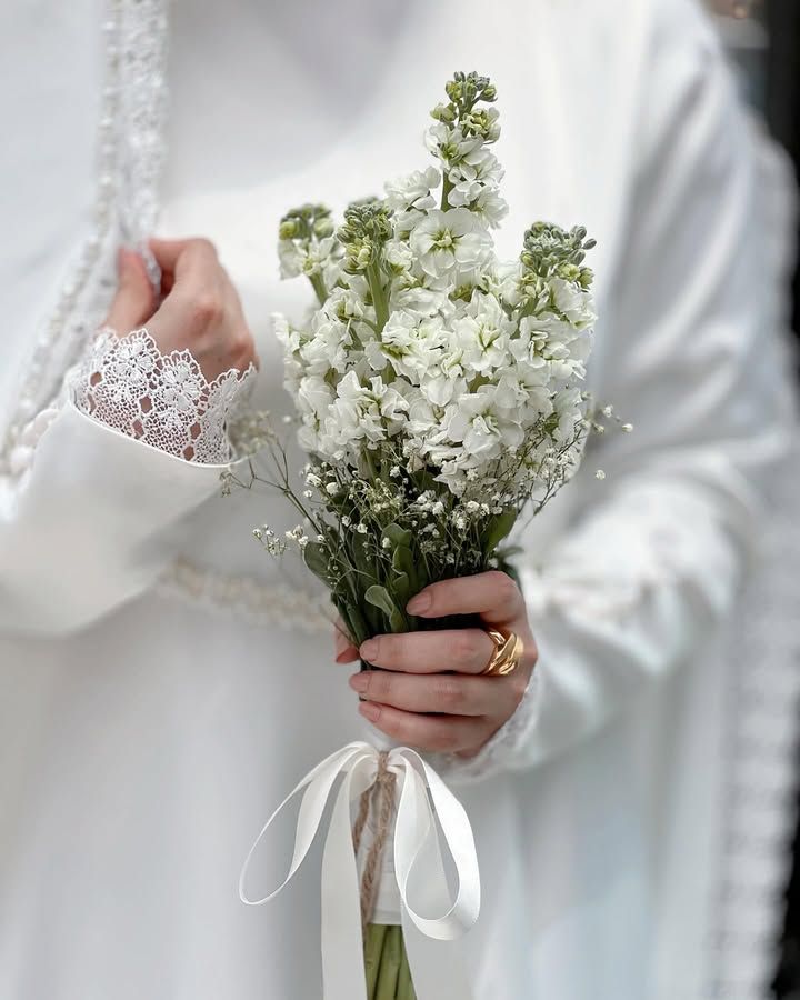 عکس دسته گل شب‌بو سفید در دست عروس با آستین گیپور