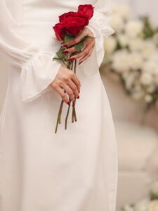 عکس عروس با لباس شیری و سه شاخه گل رز قرمز