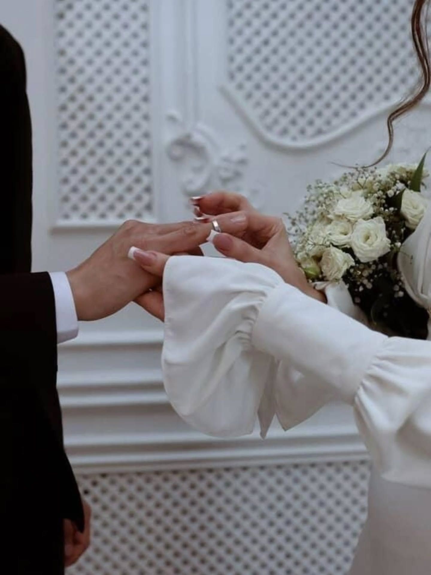 عکس لحظه دست کردن حلقه در انگشت عروس با دسته گل رز سفید