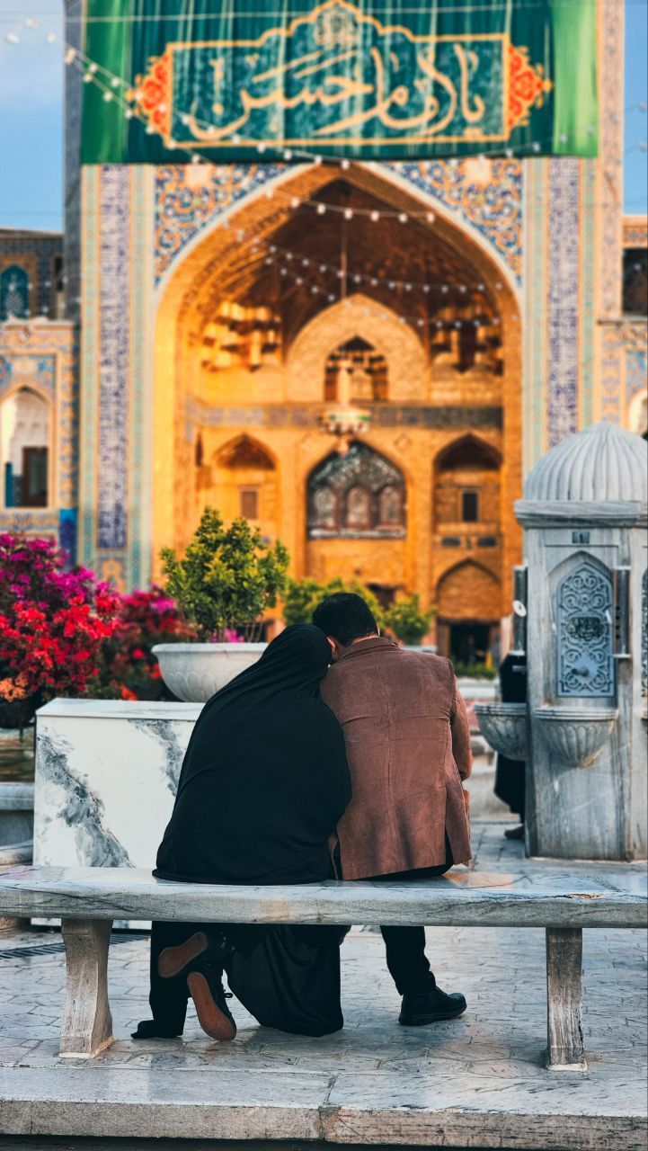 عکس عاشقانه مذهبی زوج در حیاط حرم زیر ایوان کاشی‌کاری